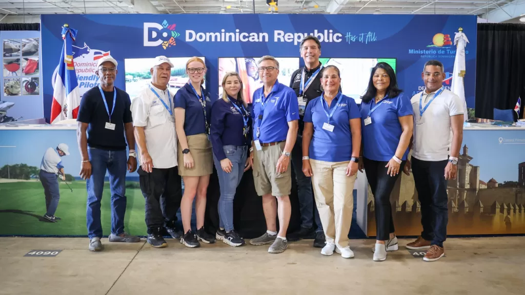 "Stand de República Dominicana en EAA AirVenture 2025, con visitantes y material promocional sobre destinos turísticos y aviación privada."