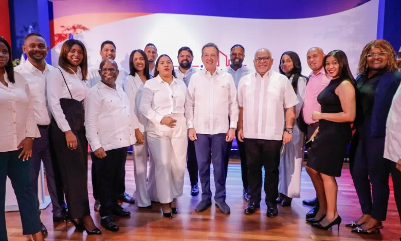 Ministro Ito Bisonó y director de Promipyme, Fabricio Gómez, durante el acto de entrega de préstamos a microempresarios en el Politécnico Loyola.