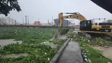 Brigadas del MOPC realizando labores de limpieza y remoción de materiales en puente flotante