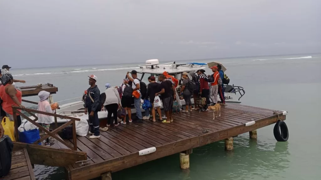 Personal de la Armada Dominicana asistiendo a personas en el puerto durante la evacuación de Isla Saona por la Tormenta Melissa.
