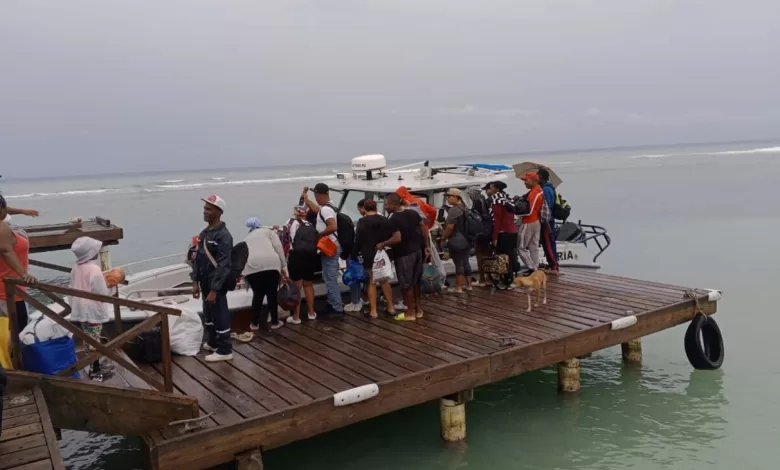 Personal de la Armada Dominicana asistiendo a personas en el puerto durante la evacuación de Isla Saona por la Tormenta Melissa.