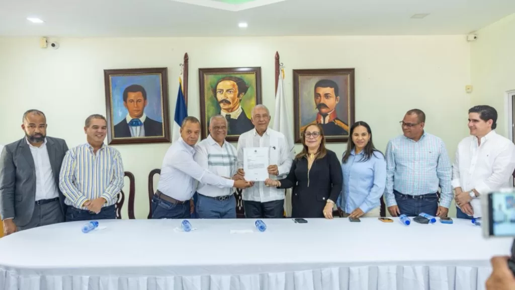 Ministro Administrativo Andrés Bautista García entregando una certificación de fondos al alcalde Domingo Almonte de Licey al Medio.