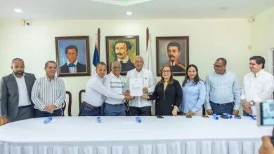 Ministro Administrativo Andrés Bautista García entregando una certificación de fondos al alcalde Domingo Almonte de Licey al Medio.