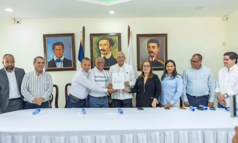 Ministro Administrativo Andrés Bautista García entregando una certificación de fondos al alcalde Domingo Almonte de Licey al Medio.