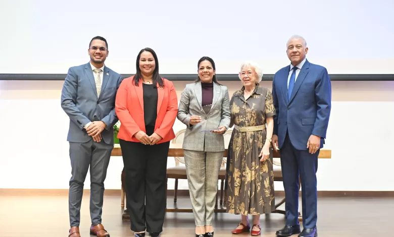 Subdirectora general del IDAC, Paola Aimée Plá Puello, recibiendo el reconocimiento de la DIGEIG de manos de Milagros Ortiz Bosch.